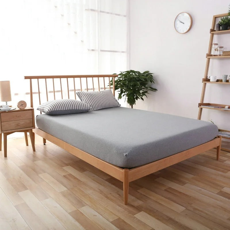 Drap housse en jersey gris sur un lit