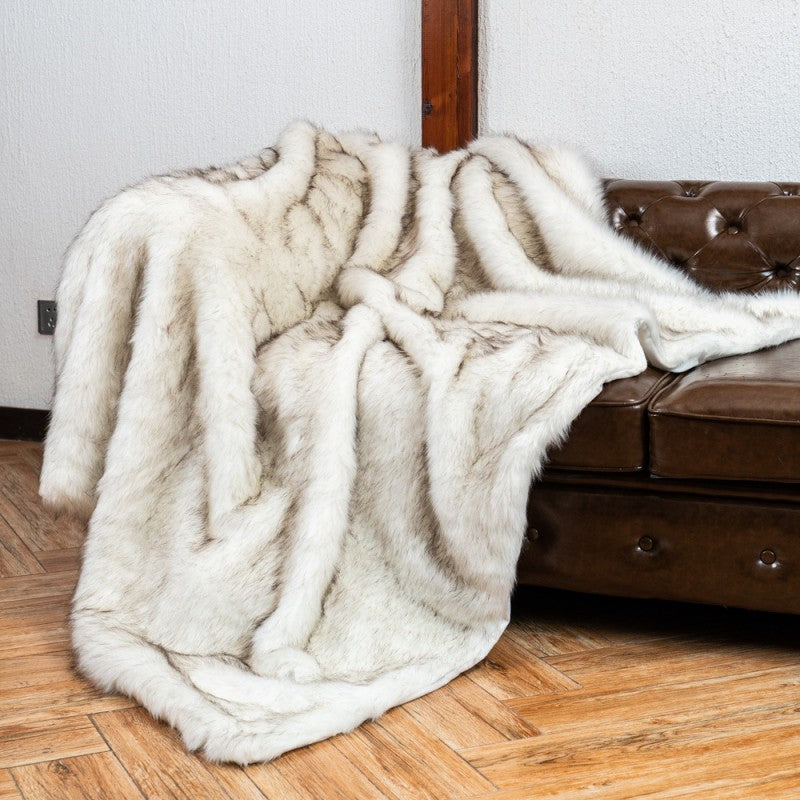 Couverture chaude en poils blancs sur un lit