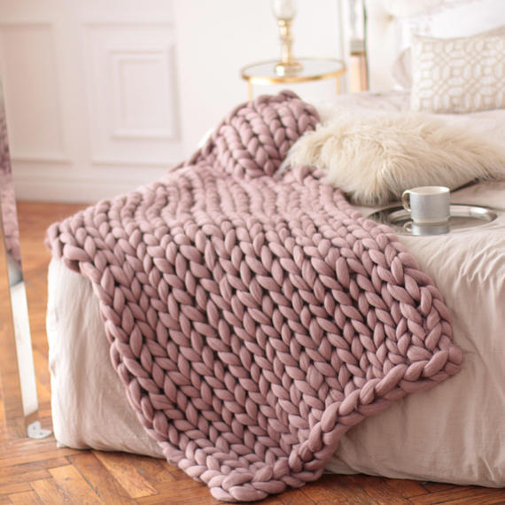 Couvertures tricotées rose sur lit
