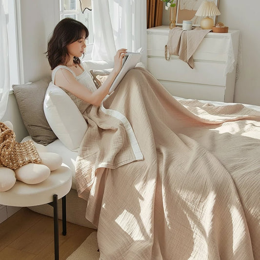 Drap en gaze de coton beige avec une femme qui lit dans son lit