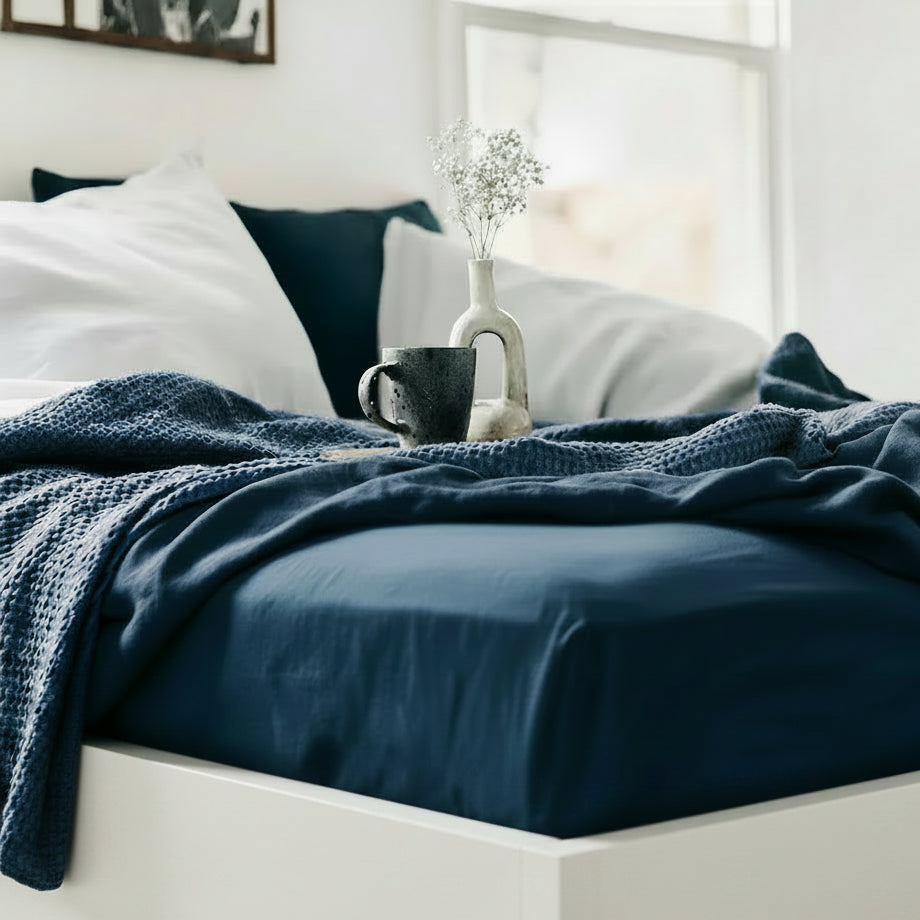 Drap housse en lin bleu sur un lit décoré