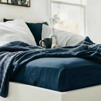 Drap housse en lin bleu sur un lit décoré