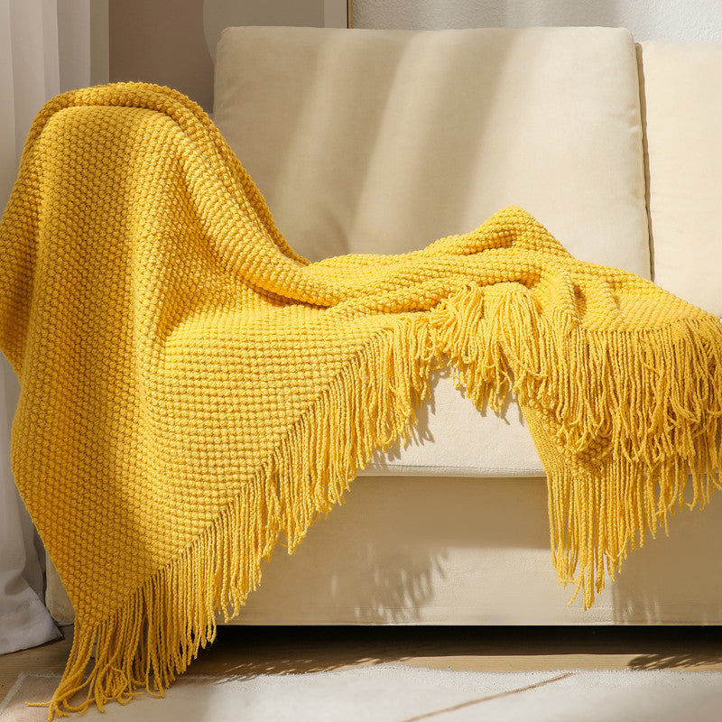 Plaid en tricot jaune sur un canapé