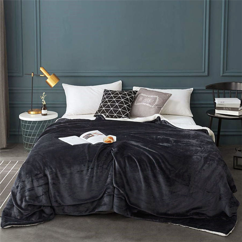 Couverture en polaire grise sur un lit