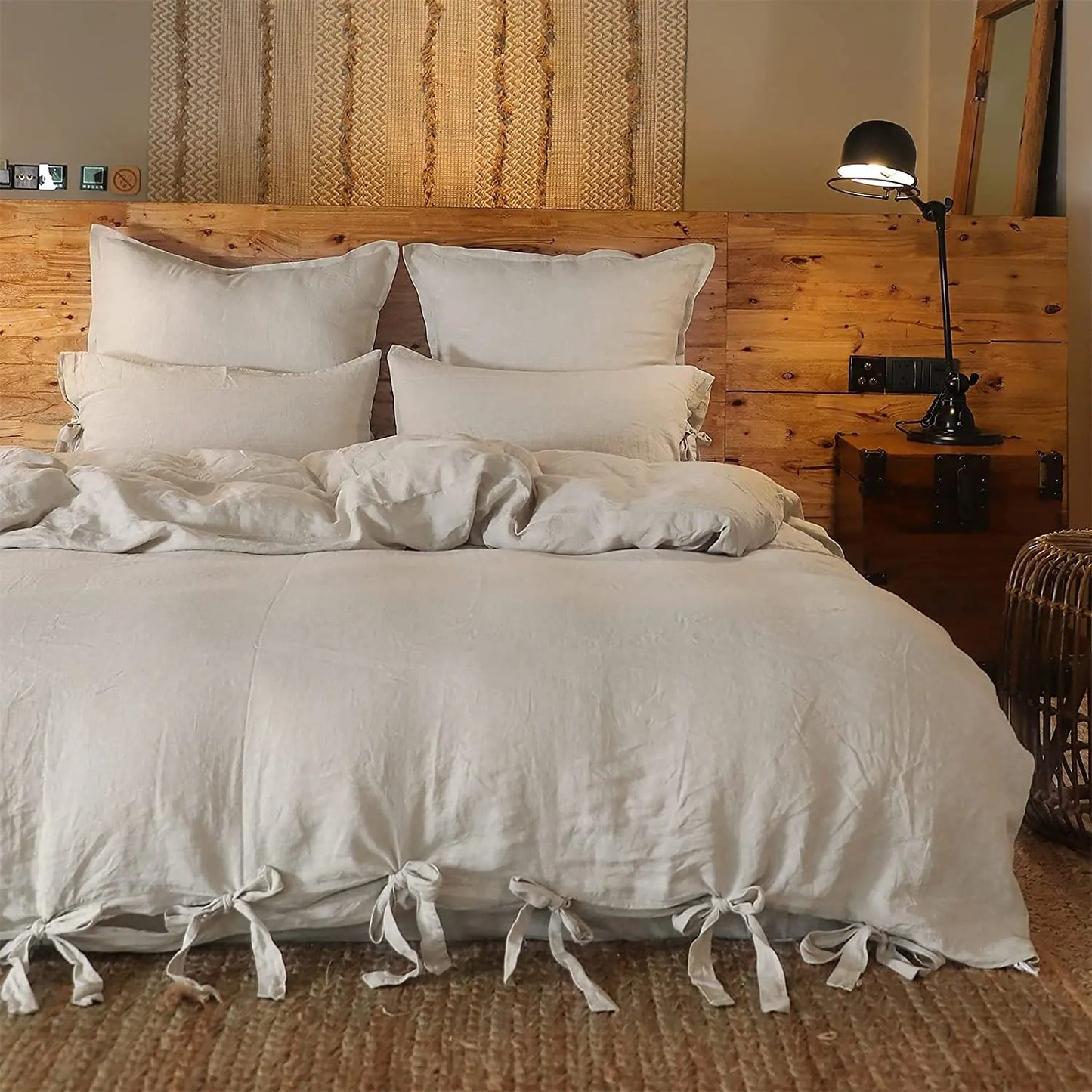 Housse de couette en lin lavé beige sur un lit avec une ambiance tamisée